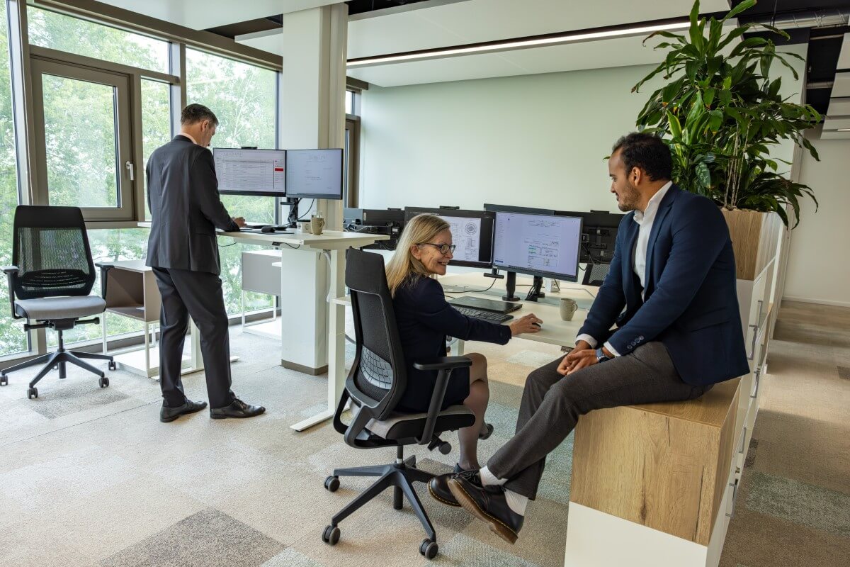 Kollegen sitzen zusammen in einem freundlichen B&uuml;ro und unterhalten sich miteinander.