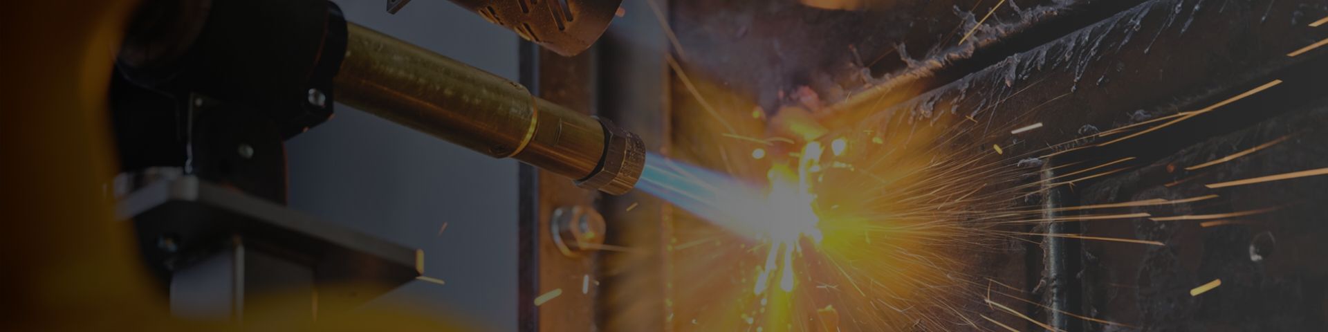 Das Bild zeigt einen Industrieroboter, der mit einem Schneidbrenner Metall bearbeitet.